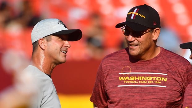 Washington Commanders coach Ron Rivera (right) and Baltimore Ravens coach John Harbaugh (left) speak before a preseason game in 2021.
